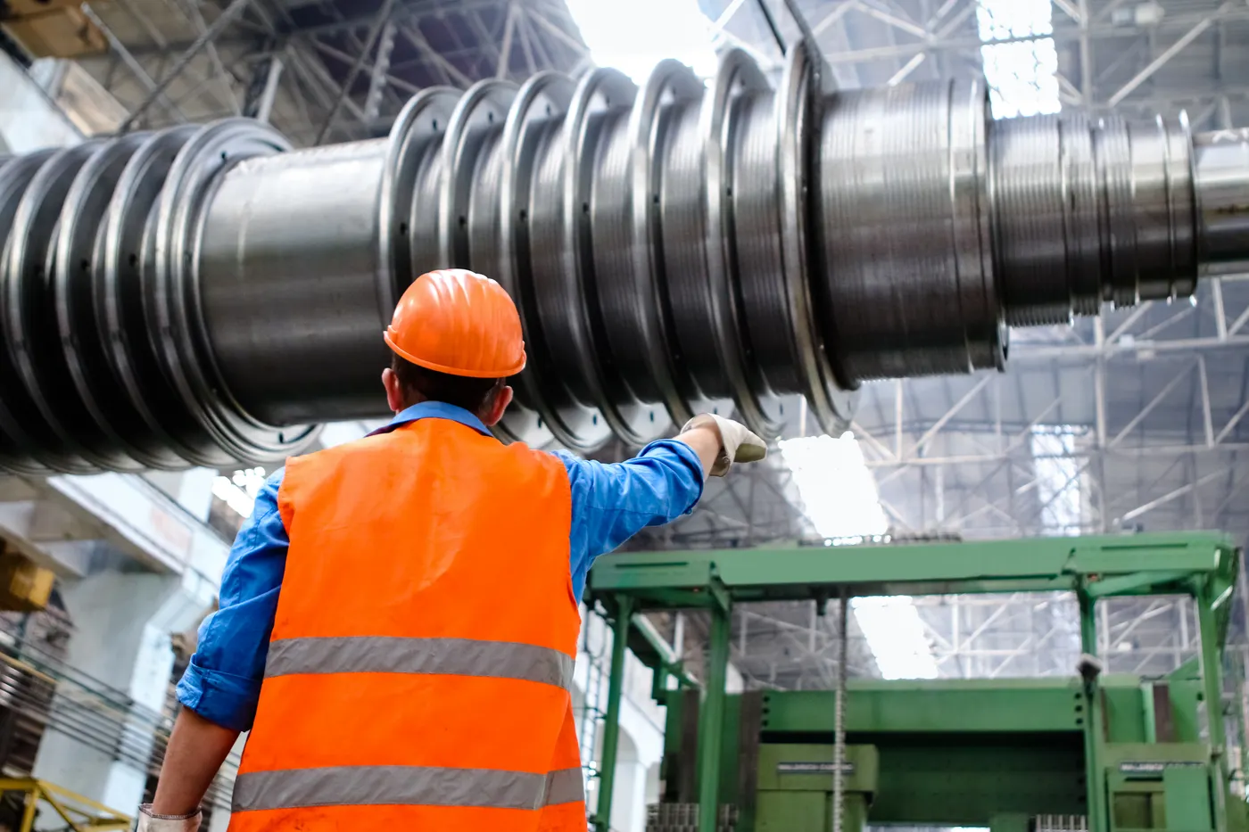 Técnico inspecionando eixo de máquina industrial de grande porte