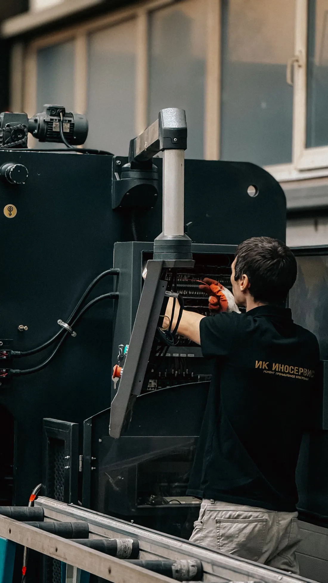 Técnico realizando manutenção em painel de máquina industrial